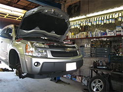 A car on a lift getting expert care at Dick's Auto Service of Clinton